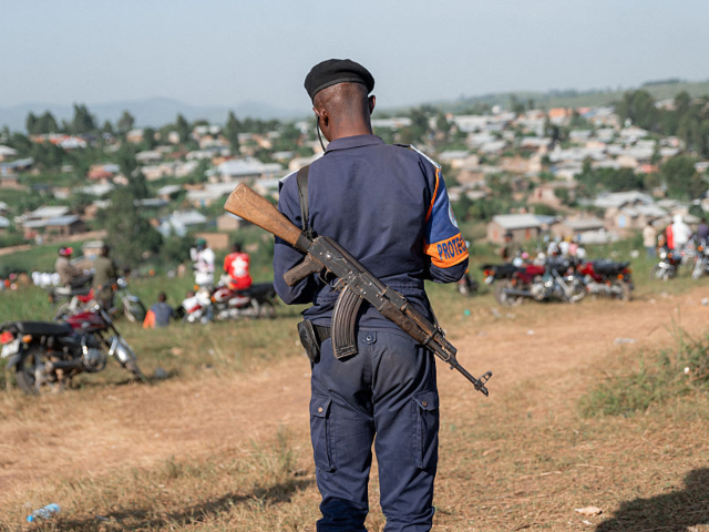 TOPSHOT - A Democratic republic of Congo policeman stands guard at the Nyamurongo cemetery