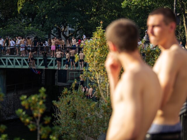 Young people swim in the Canal Saint-Martin in Paris, France, on June 21, 2026. The activi