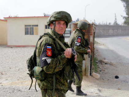 Russian military police members stand guard at the Wafideen checkpoint on the outskirts of