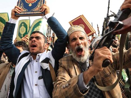 Supporters of the Iran-backed Houthi movement brandish their weapons and copies of the Qur