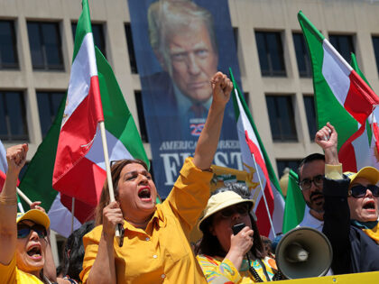 Supporters of Iranian dissident politician Maryam Rajavi wave pre-revolution Iranian flags