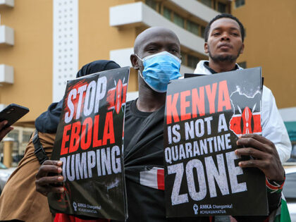 Activists wearing protective suits carry placards during a march to protest the Kenyan gov