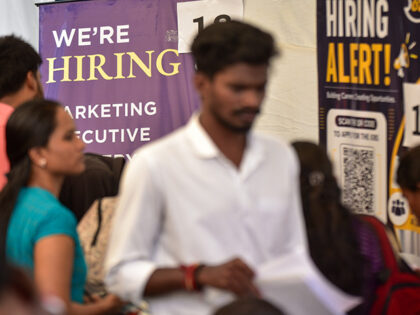 Job seekers walk past hiring posters during a job fair organized by the India National Con