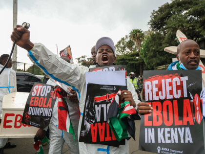 NAIROBI, KENYA - JUNE 02: Activists wearing protective suits carry placards during a march