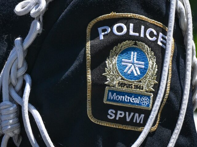 A police officer with a visible patch of the Montreal Police Service (SPVM Service de poli