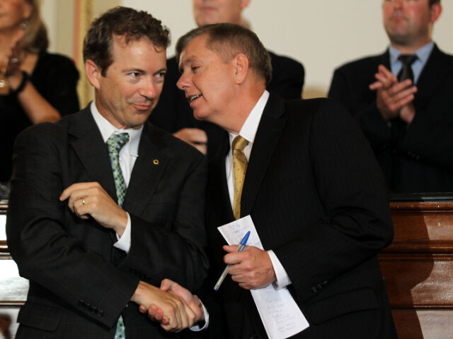 U.S. Sen. Rand Paul (R-KY) (L) shakes hands with Sen. Lindsey Graham (R-SC) (R) during a n