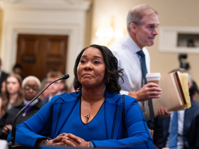 Rep. Jim Jordan, R-Ohio, walks by Regina Wallace-Jones, CEO of ActBlue, as she prepares to