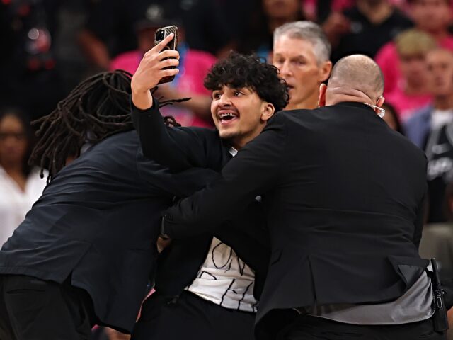 SAN ANTONIO, TEXAS - JUNE 03: A fan is detained by security after running on the court dur