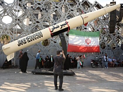 Iranians stand next to a symbol of a Kheibar missile as they take part during a rally in s