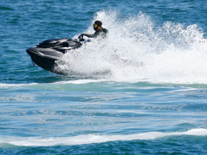 People cool off by playing on jet skis at Yeong Il seashore in Pohang, South Korea, on Jul