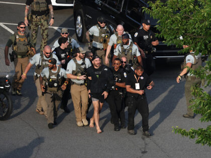 MMA fighter Sean Strickland is escorted out of the UFC Freedom 250 Fan Fest on The Ellipse