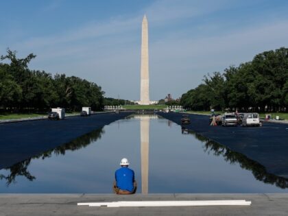 A worker sits as the Lincoln Memorial reflecting pool is filled with water after being pai