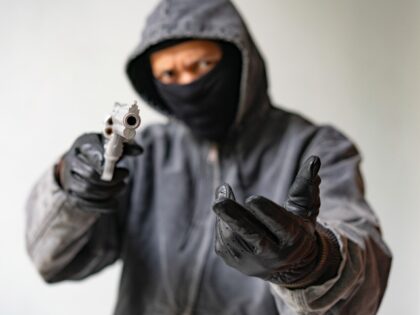 Bandit carrying a gun, wearing a black mask, robbed.