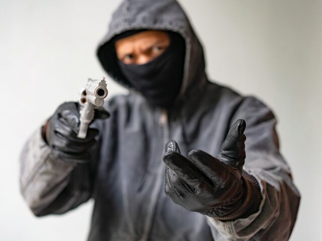 Bandit carrying a gun, wearing a black mask, robbed.