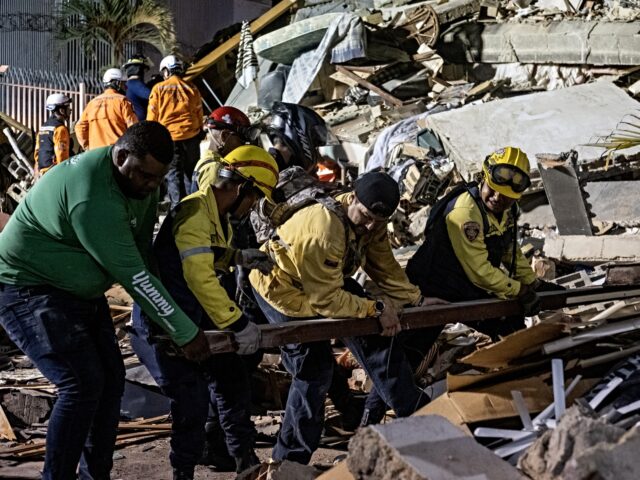 CARACAS, VENEZUELA - JUNE 24: Rescue workers search through the rubble of a collapsed buil