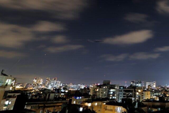 Rocket trails are seen above the Israeli coastal city of Netanya, as air raid sirens sound