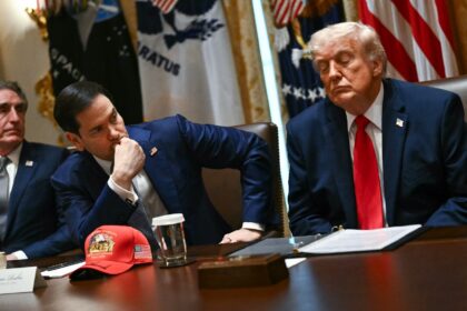 US Secretary of State Marco Rubio (center) and US President Donald Trump (right) listen du