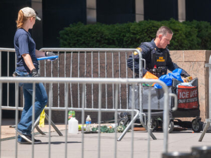 Law enforcement investigates the scene after an incendiary device went off outside of 26 F