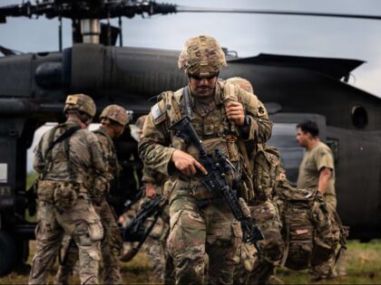 Soldiers exit a UH-60 Black Hawk helicopter during insertion and extraction training as pa