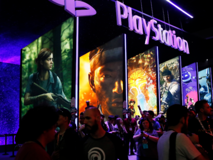 FILE - In this June 14, 2018, file people stand online next to the PlayStation booth at th