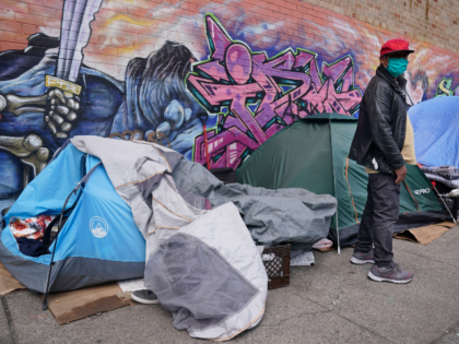 Sotero Cirilo stands near the tent, left, where he sleeps next to other homeless people in