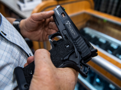 FILE - A customer checks out a hand gun that is for sale and on display at SP firearms on