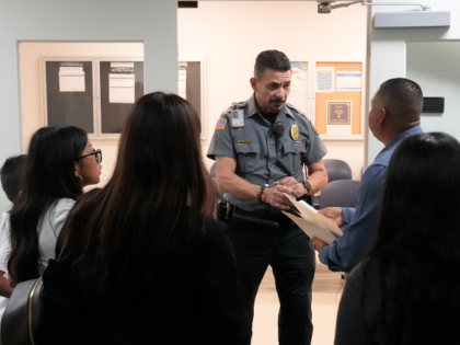 An officer listens to a question as he directs people to a courtroom, Wednesday, Jan. 10,