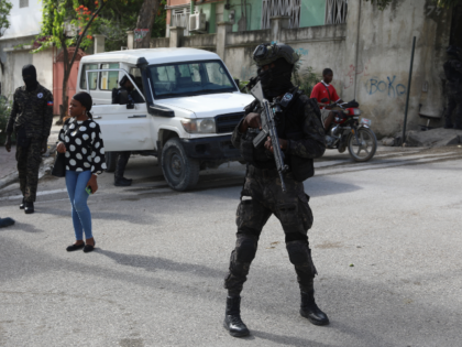 Police stand guard outside the Electoral Council (CEP) during a visit by Frinel Joseph, ad