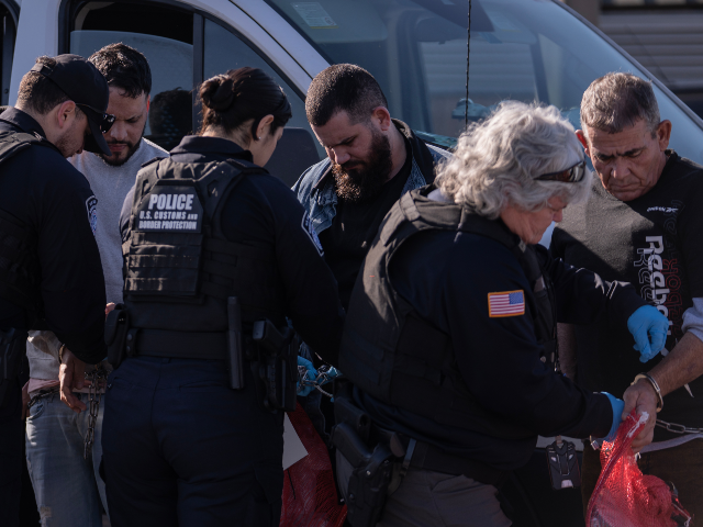 AP26073045221789 ICE agents remove chains and handcuffs from a group of undocumented migrants before they a