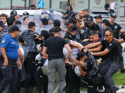 Police patrol as protestors from the People's Liberation Party demonstrate against th
