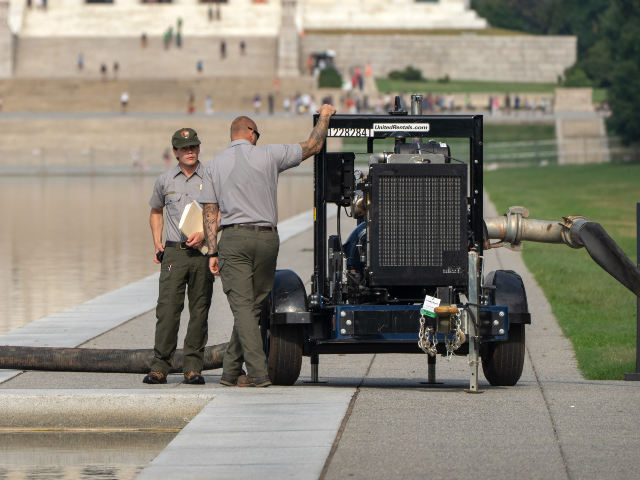 National Park Service workers stand near a pump placed next to the Lincoln Memorial Reflec