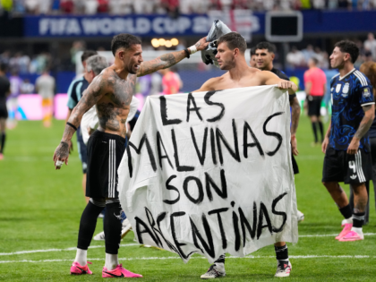 Argentina's Giovani Lo Celso holds a banner with the words "The Malvinas are Arg