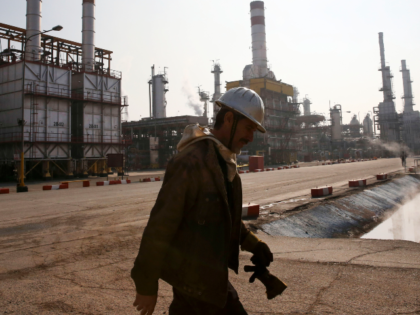 FILE - In this Dec. 22, 2014 file photo, an Iranian oil worker makes his way through Tehra