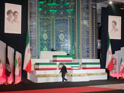 A man walks by coffins containing the late Iranian Supreme Leader, Ayatollah Ali Khamenei,