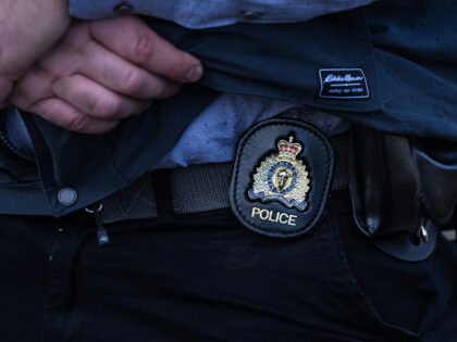 A police officer's badge is visible on a member of the police force as President Andr