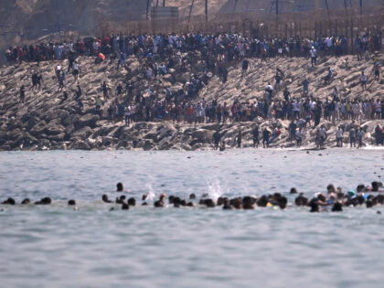 Migrants cross from Morocco into the Spanish enclave of Ceuta, Thursday, July 30, 2026. An