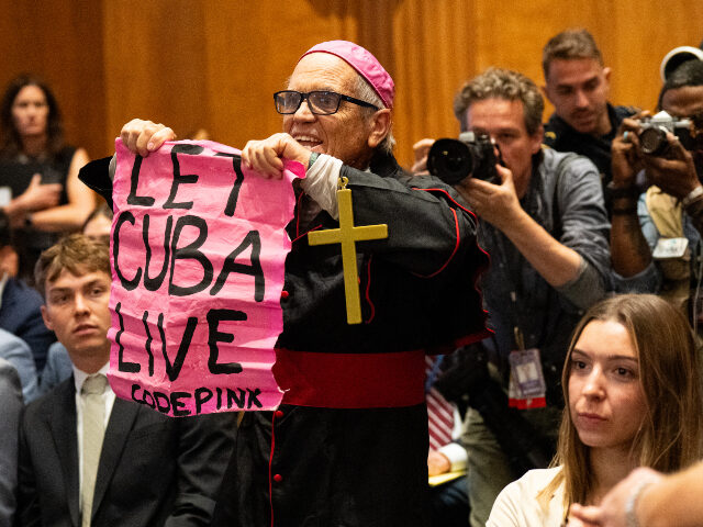 Code pink CodePink protester dressed as a pop holds a "let Cuba live" sign as Secretary of