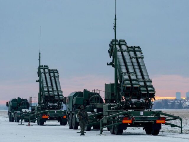A soldier stands next to PATRIOT (Phased Array Tracking Radar to Intercept on Target) surf