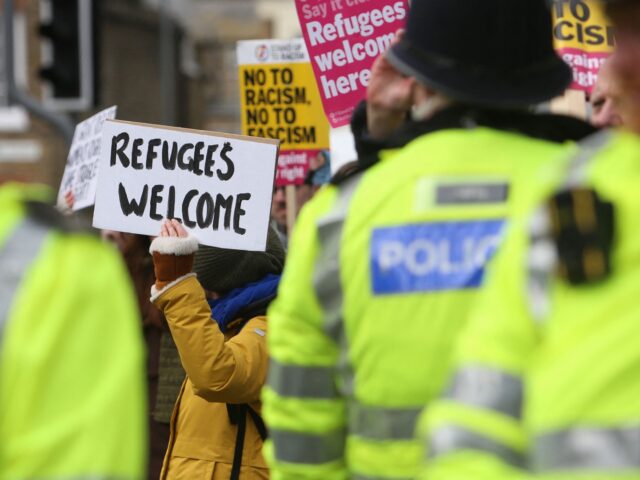 Police officers monitor pro-refugee supporters in Dover on the south-east coast of England