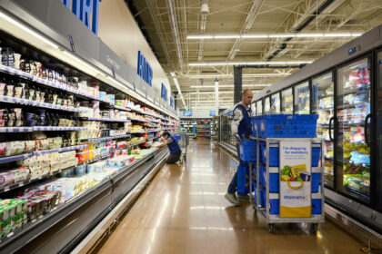 Workers stock shelves in a grocery aisle at a Walmart store on Black Friday in Columbus, O
