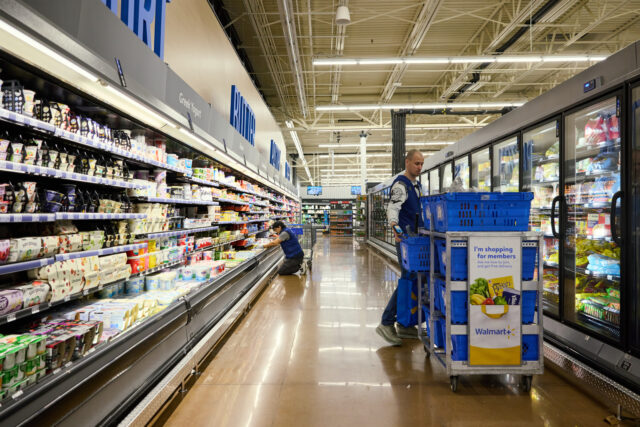 Shoppers At A Walmart On Black Friday Workers stock shelves in a grocery aisle at a Walmart store on Black Friday in Columbus, O