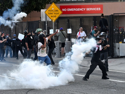 Los Angeles, CA - March 28: Protestors throw projectiles after police fire tear gas into t