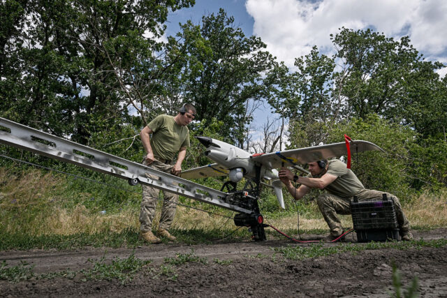 Technicians prepare to launch a Ukrainian Raybird (ACS-3) UAV from a catapult during an ae