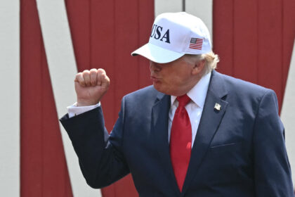 US President Donald Trump raises a fist as he arrives to speak at the Burning Hills Amphit