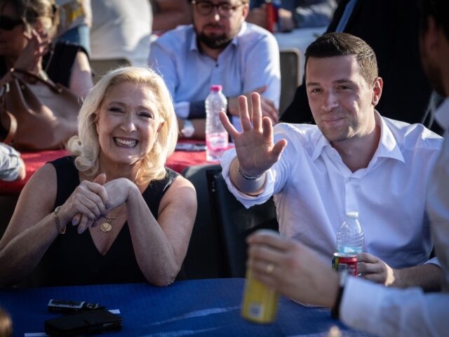 President of Rassemblement National parliamentary group Marine Le Pen (L) reacts next to F
