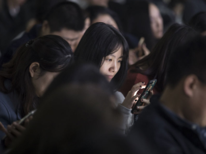 An attendee uses her smartphone during Tencent Holdings Ltd.'s WeChat Open Class Pro confe