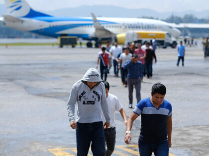 Guatemalans walk off a plane during the arrival of a flight coming from Mesa, Arizona with