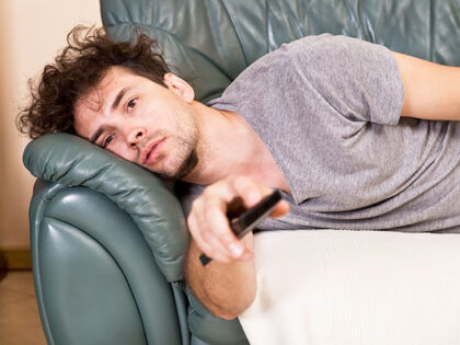 lazy man watching tv on couch