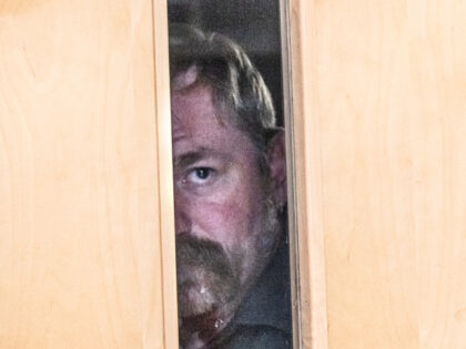 Democratic U.S. Senate candidate Graham Platner peeps through the door before walking out