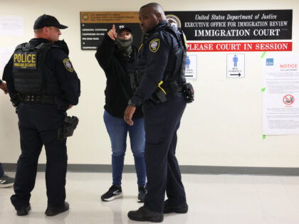 Homeland Security officers speak with a federal agent as they patrol the halls of immigrat